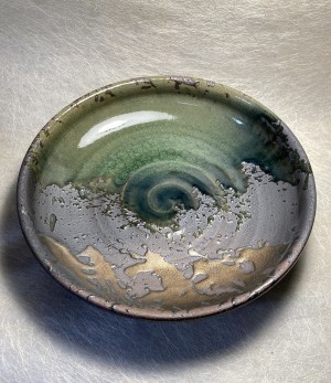 Schaal rond zwart met groen en goud.